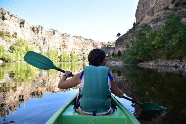 Obraz young woman paddling in a canoe over the waters of las hoces del rio duratón