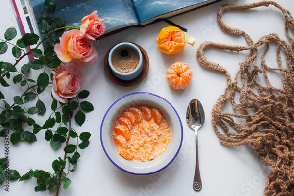 Fototapeta breakfast with a cup of coffee and some tangerines