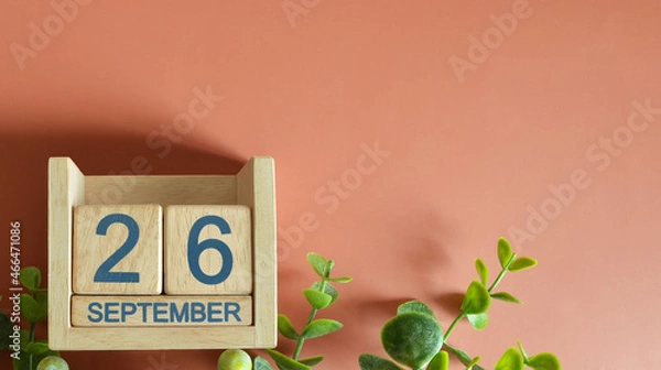 Fototapeta September 26, Date design with calendar cube and leaf on orange background.