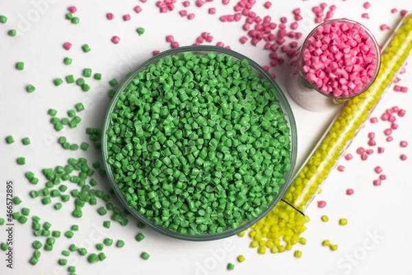 Fototapeta Green, yellow and pink  granules of polypropylene or polyamide on a white background. Plastics and polymers industry. Copy space. Glass petri dish, flask, volumetric glassware, test tube. 
