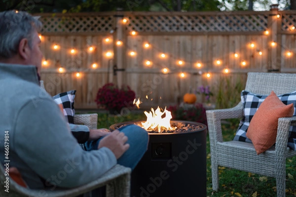Obraz Man relaxing in the backyard by a fire