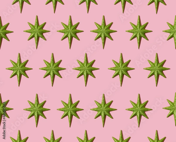 Obraz Creative festive pattern made of Christmas green stars on pastel pink background. Minimal New Year idea with ornaments. Aesthetic flat lay.