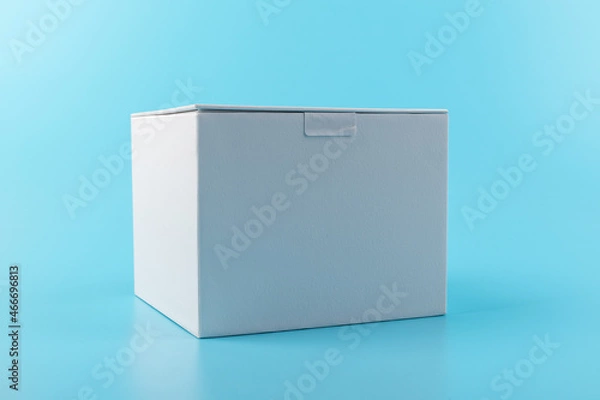 Fototapeta Opened white paper cube box on a blue background.