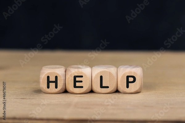Fototapeta Wooden cube with the word HELP on wooden table.
