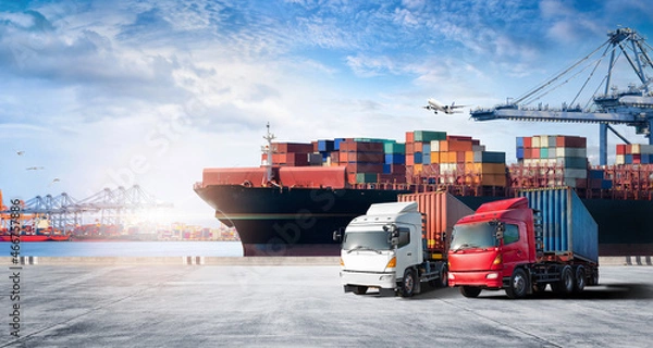 Obraz Container cargo freight ship during discharging at industrial port and move containers to container yard by trucks, cargo plane, logistic import export background and transport industry concept