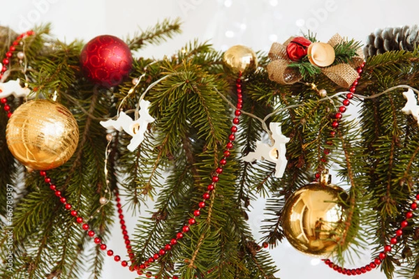 Obraz a branch of a Christmas tree with decorations and garlands in the form of deer