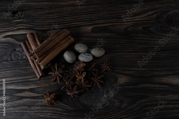 Obraz Natural cinnamon stick seasoning with anise stars and nutmeg on a brown wooden background, top view