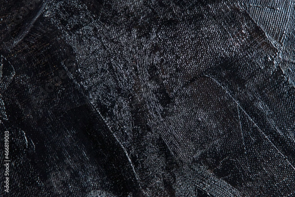 Fototapeta Dark creative background - rough linen canvas unevenly covered with black primer, reflections of light. Toning, blurring, selective focus.