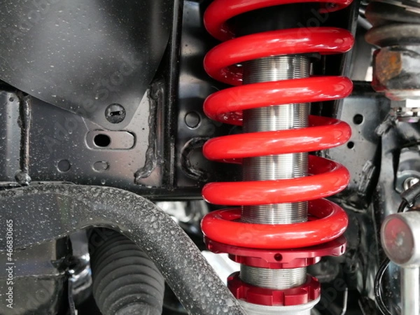 Obraz red shock absorbers of car at garage.