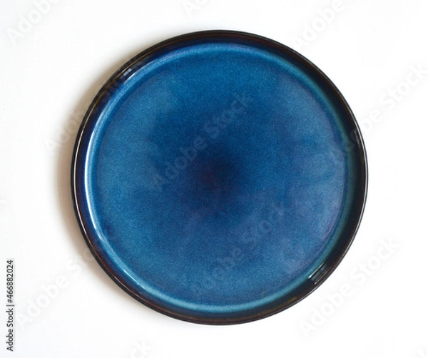 Fototapeta round blue handmade ceramic plate isolated on a white background