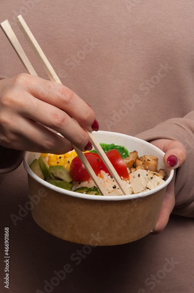Obraz the girl eats a vegetarian poke. vertical frame