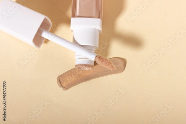Fototapeta Concealer cream on a background with shadows. Face corrector on beige background with copy space. Blank mockup for product