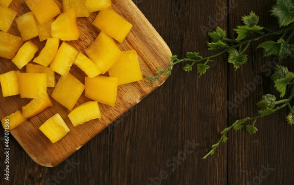 Obraz 木製テーブルにあるまな板の上のカットされたパプリカ