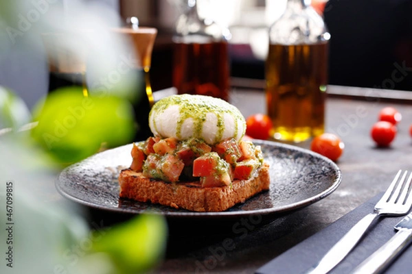 Fototapeta Bruschetta with burrata and basil pesto.
Appetizing dish. Culinary photography, a proposal to serve a meal.