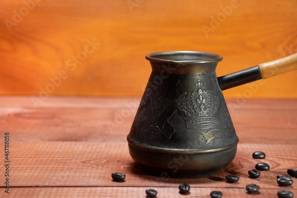 Fototapeta Used metal coffee turk, old, vintage turk, on the background of coffee beans on real tree with a place for text. Turkish Jezve Coffee Pot, crop image 