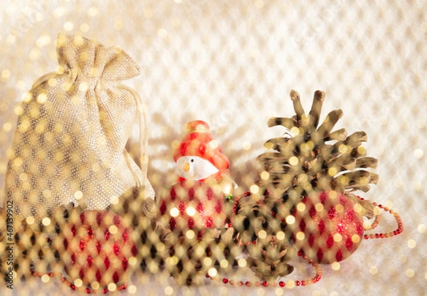 Fototapeta a view of a Christmas composition with a gnome, fir cones and a bag was taken from under the curtain