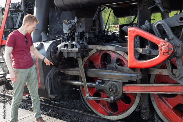 Fototapeta a 30-year-old man points to the mechanism of the wheels