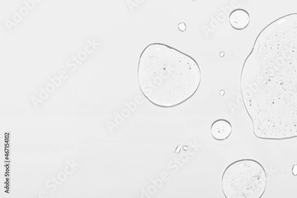 Obraz Cosmetic product clear drops and space for design on white surface close upper view. Skincare and dermatological procedures