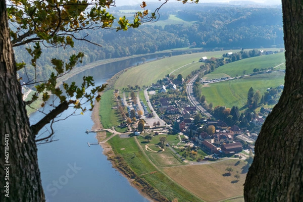 Fototapeta Top view between trees of a small village by the river in summer in Europe