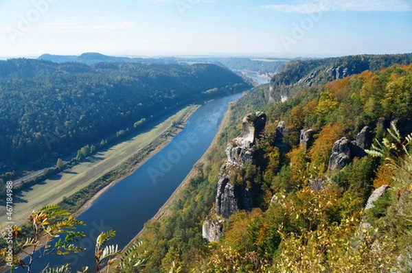 Fototapeta River between high banks with rocks in autumn in Germany