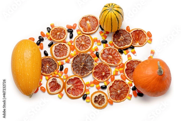 Obraz Dried orange slices, candies, squash, and pumpkin isolated on a white background from above.