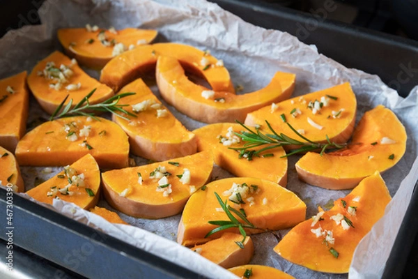 Fototapeta Preparation autumn dishes from pumpkin. On a baking sheet, on a rustic wooden old table.