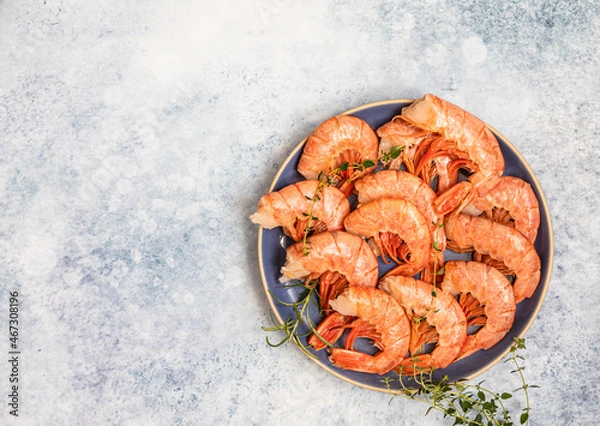Obraz Raw red Argentine shrimps on ceramic plate, blue concrete background. Ocean jumbo shrimps. Top view.