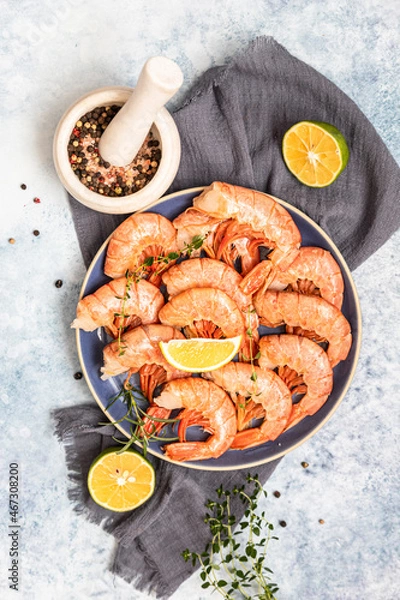 Obraz Fresh shrimps or prawns with lime, pepper and herbs on blue concrete background. Seafood. Top view.