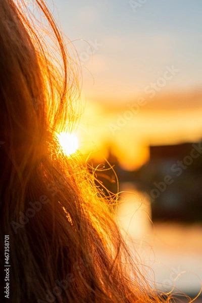 Fototapeta Sunshine shining through long and curly hair during the golden hour. Abstract and calm mood