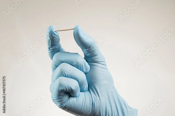 Obraz hand in rubber gloves holding a hormonal implant.