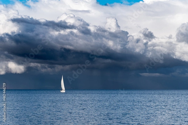 Fototapeta Panoramic view of a sailboat with a background full of storm clouds on lake llanquihue in frutillar, Chile.