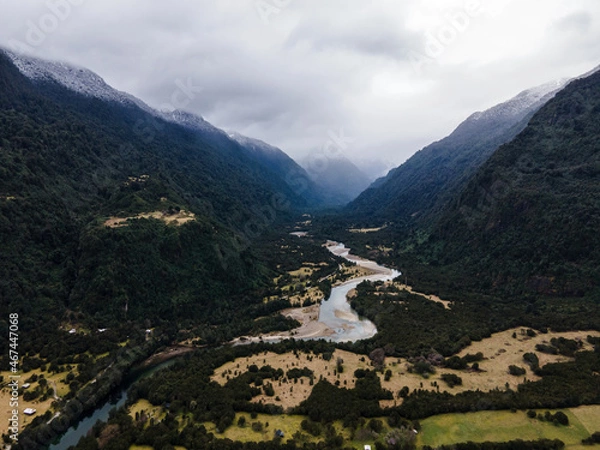 Fototapeta Aerial view of the Cochamo valley with its snow-capped mountains and its characteristic river.