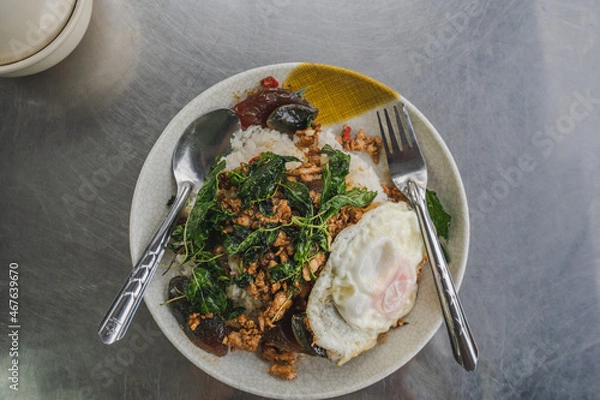 Obraz Stir fried basil century egg with pork and fresh bird's eye chili on topped boiled rice and fried egg is popular thai style street food.	