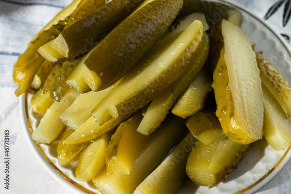 Fototapeta Sliced green pickles on a plate on the table