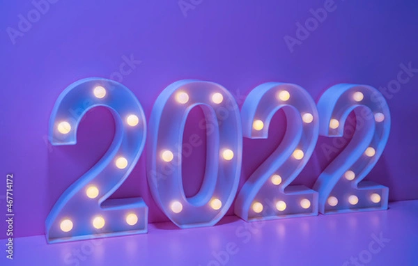 Fototapeta New Year 2022 Creative Design Concept numbers from yellow bulbs on purple background