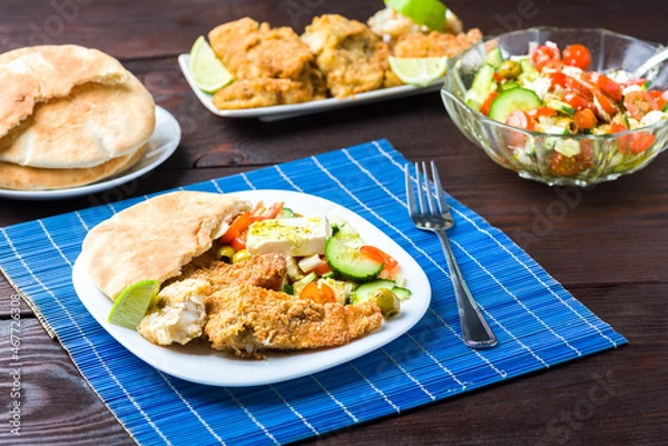 Fototapeta Baked fish served with vegetable salad with feta cheese