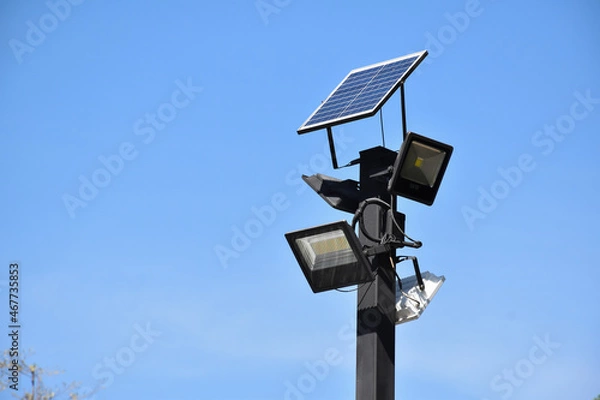 Fototapeta Photovoltaic panel which installed on the top of the metal pole to store and use the sun power around the public park at night.