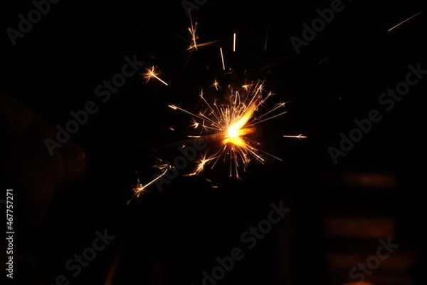 Fototapeta A burning sparkler on the black