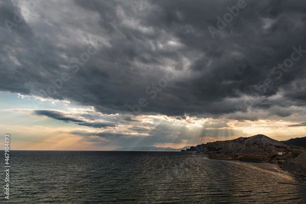 Obraz sun rays passing through the clouds over the sea