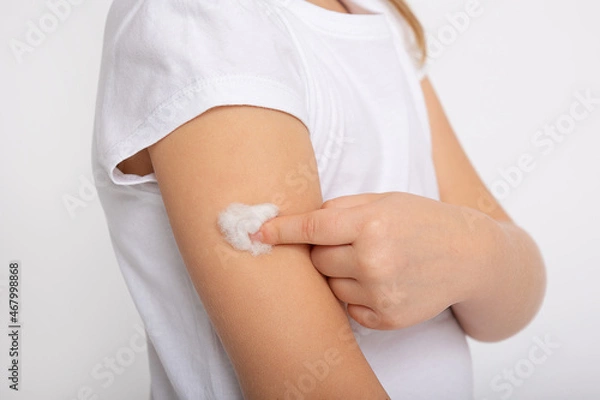 Fototapeta after vaccination with covid 19. The girl gets an injection in the shoulder. Concept of clinical trials of a vaccine for children, coronavirus