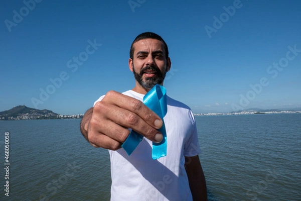 Obraz Prostate cancer awareness, man holding light blue ribbon to support people living and disease. World Cancer Day and Men's Health Concept