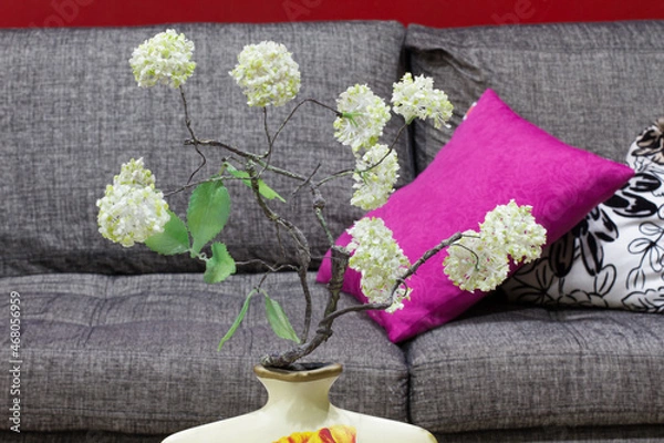 Fototapeta Cozy living room with couch and cushions, adorned with withe flowers
