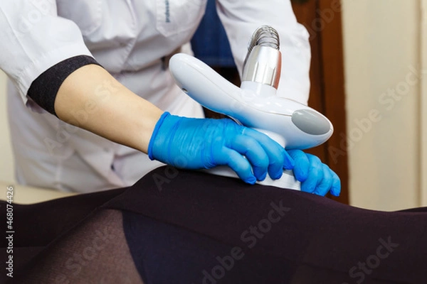 Fototapeta Manipula of LPG massage in the hands of a beautician.