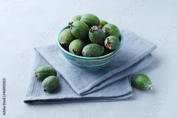 Fototapeta Feijoa fruits in the bowl on a gray concrete background. Selective focus.