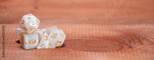 Fototapeta Set of role playing white dices on a gaming table made of wood: banner for Dungeons and Dragons role-playing games with place for text
