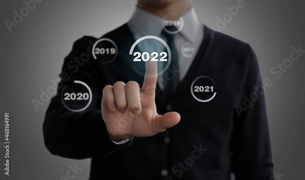 Fototapeta Businessman clicks on the 2022 button. Switches years. Chose the 2022 new year