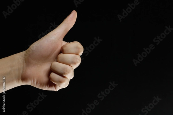 Obraz thumbs up on a black background
