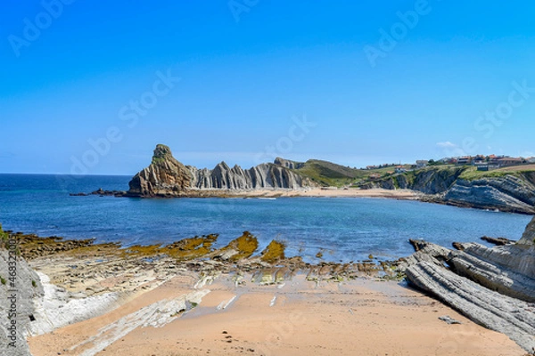 Obraz View of Portio beach in Liencres, with its colored sand and rocks.