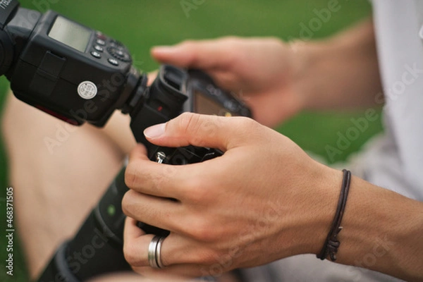 Obraz クリップオンストロボを用意して準備しているカメラマン