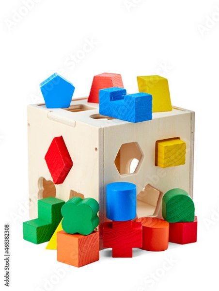 Fototapeta Wooden children's toy that develops a child's fine motor skills, consisting of three-dimensional geometric shapes and holes in a cube for them, isolated on a white background with a shadow.